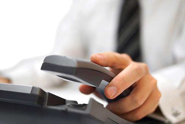 man's hand hanging up a phone